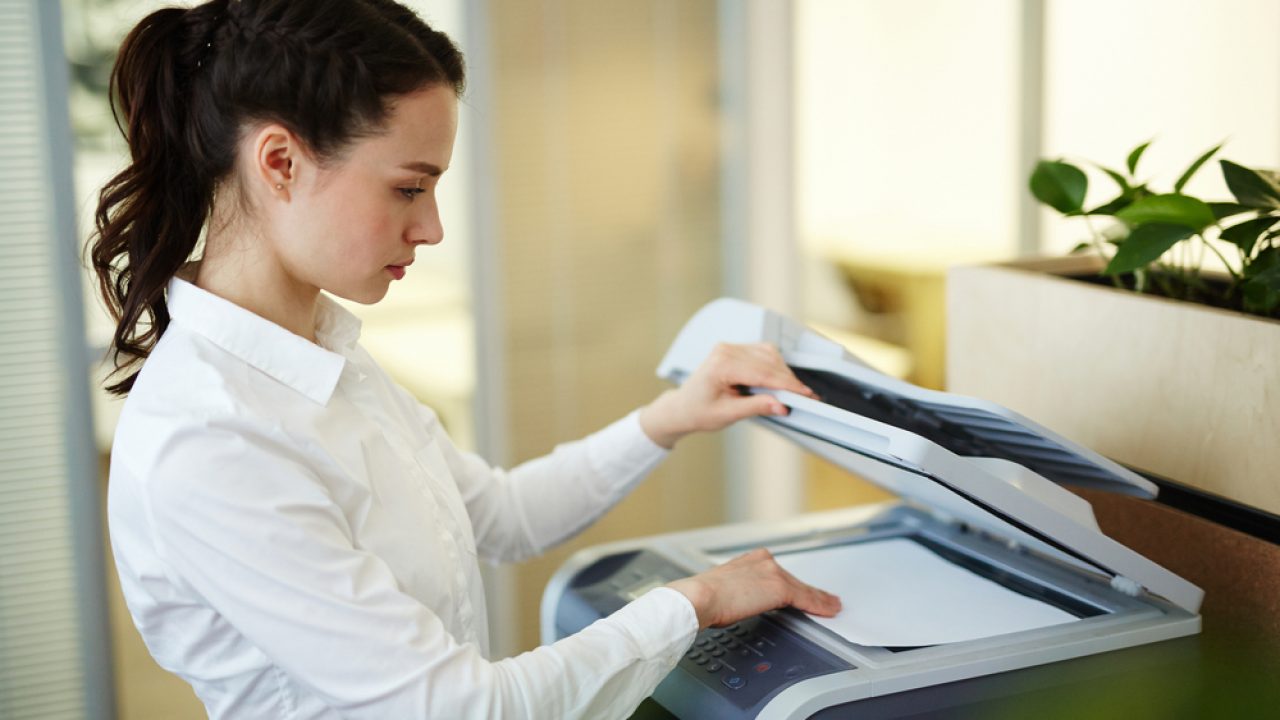 Gestión documental Chica escaneando un documento en una máquina de impresión